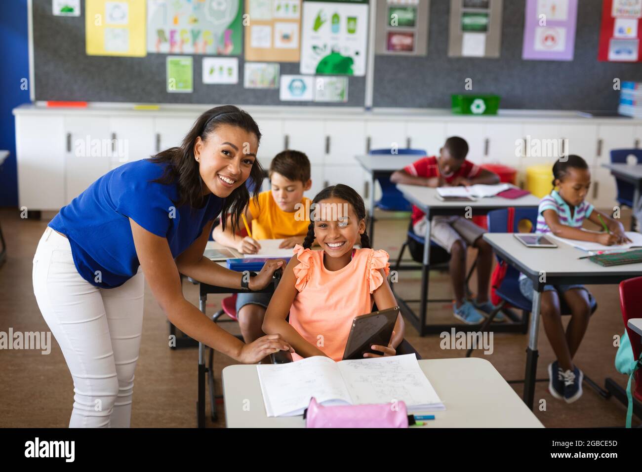 portrait-of-african-american-female-teacher-and-disabled-girl-smiling-in-class-at-elementary-school-2GBCE5D